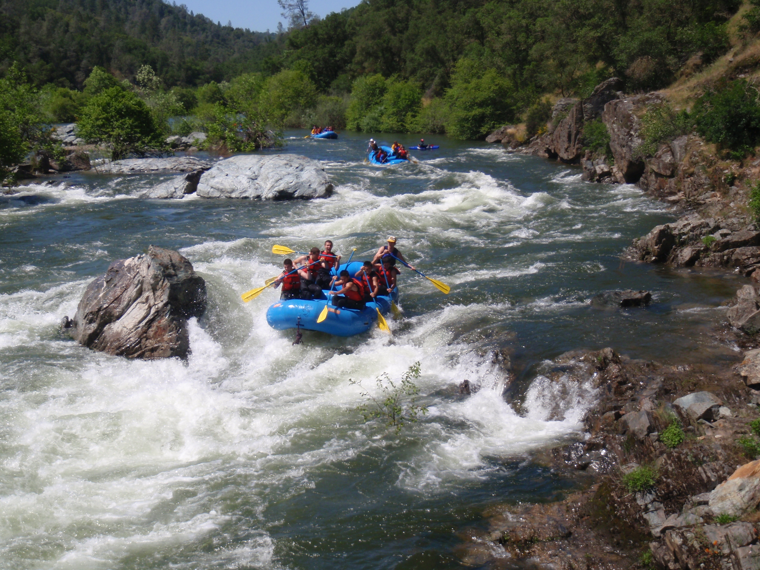 Groups rafting down river rapids